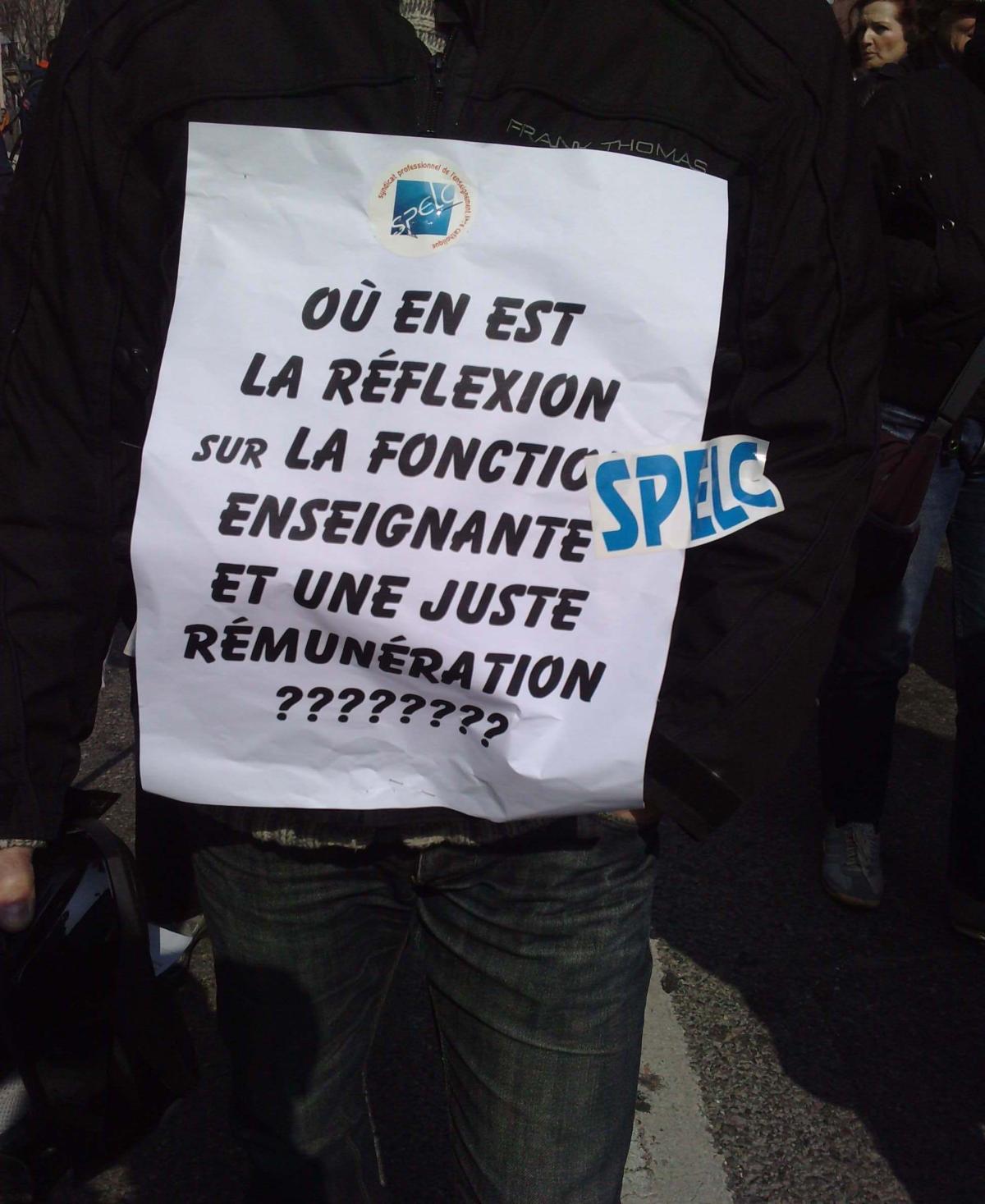 militant porte une affiche : ou en est la réflexion sur la fonction. enseignante et une juste rémunération ??????????