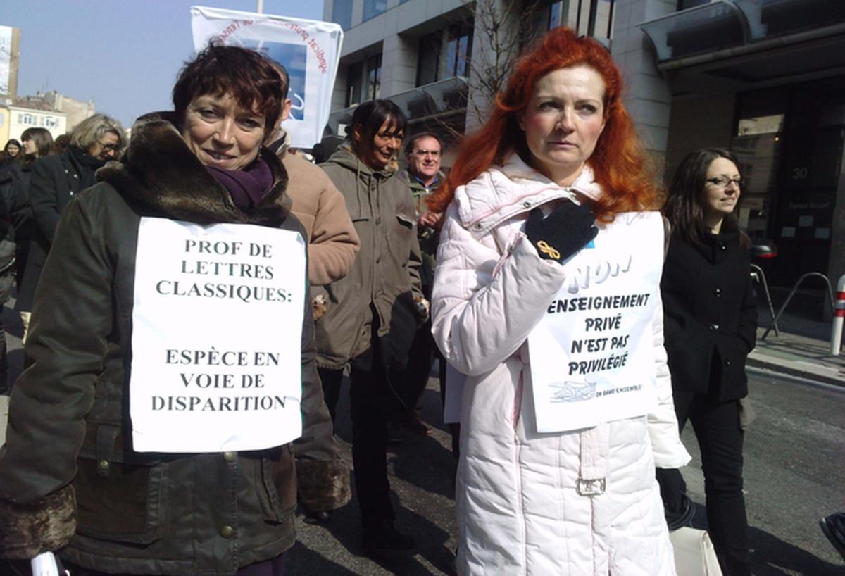 enseignantes porte deux affiche:PROF DE LETTRES CLASSIQUES:espéce en voie de disparetion- ENSEIGNEMENT privé n'est pas privilégée