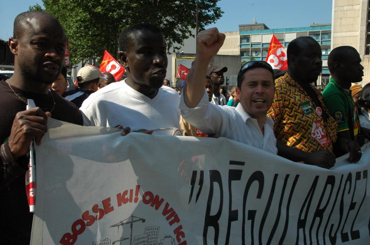 travailleurs Sans-Papiers tenant leur banderole de l'Intersyndicale.