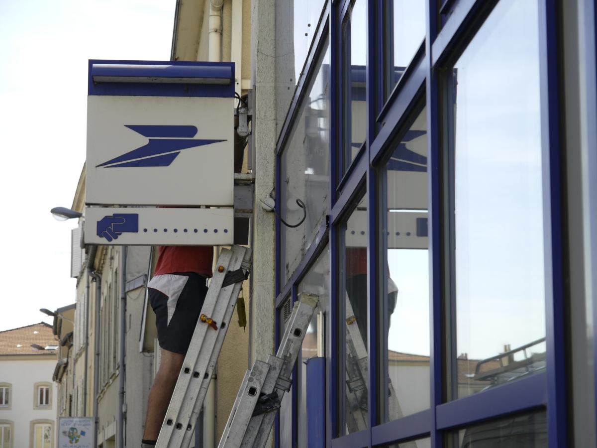 Enseigne de la Poste en cours de démontage