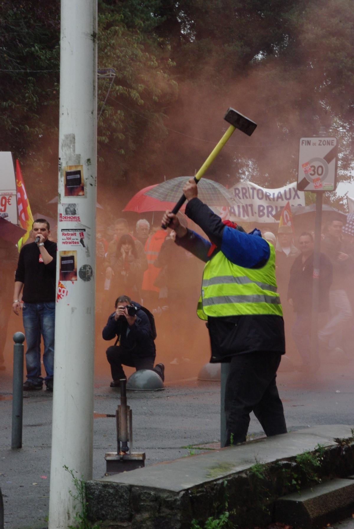 militant de la CGT cheminot avec une masse déclanchant un puissant pétard