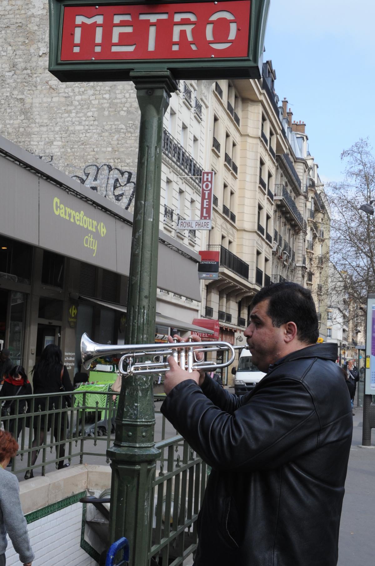 Trompettiste Roms faisant la manche à la sortie du Métro Parisien