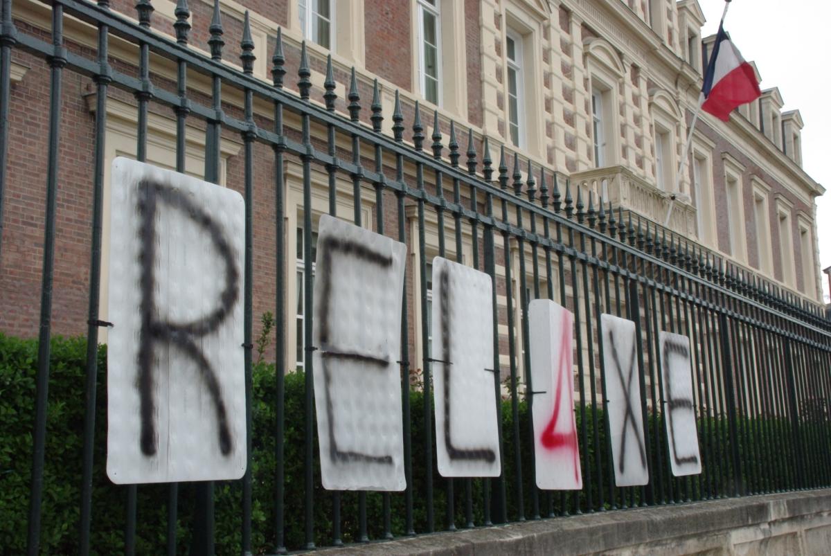 pancartes demandant la relaxe des 4 militanst sur les grilles de la sous préfecture