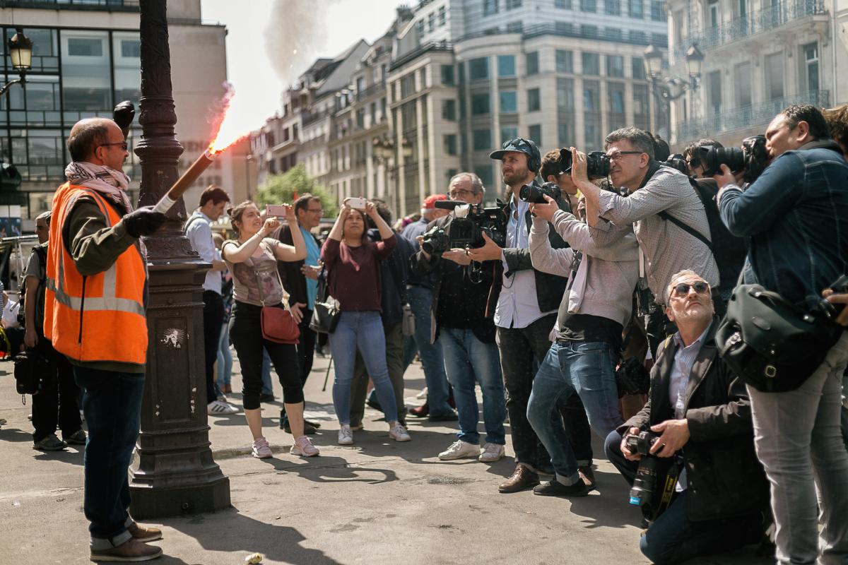 Des photographes autour d'un cheminot qu venait d'allumer un fumigène