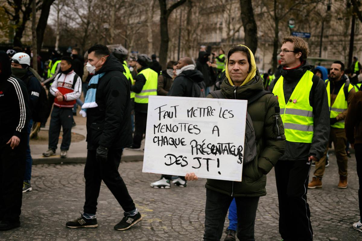 Pancarte: Faut mettre des menottes à chaque présentateur télé