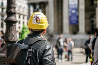 Un cheminot avec un casque et un autocollant regarde La Bourse