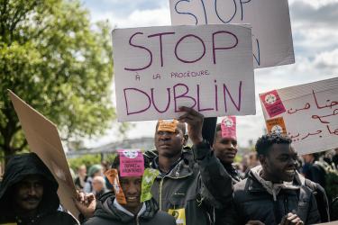 Des migrants avec des pancartes stop à la procédure Dublin