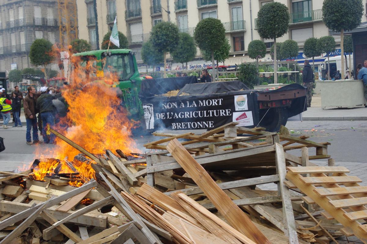tracteur et sa remorque contre l amort de l'agriculture , au premier plan feux de palettes