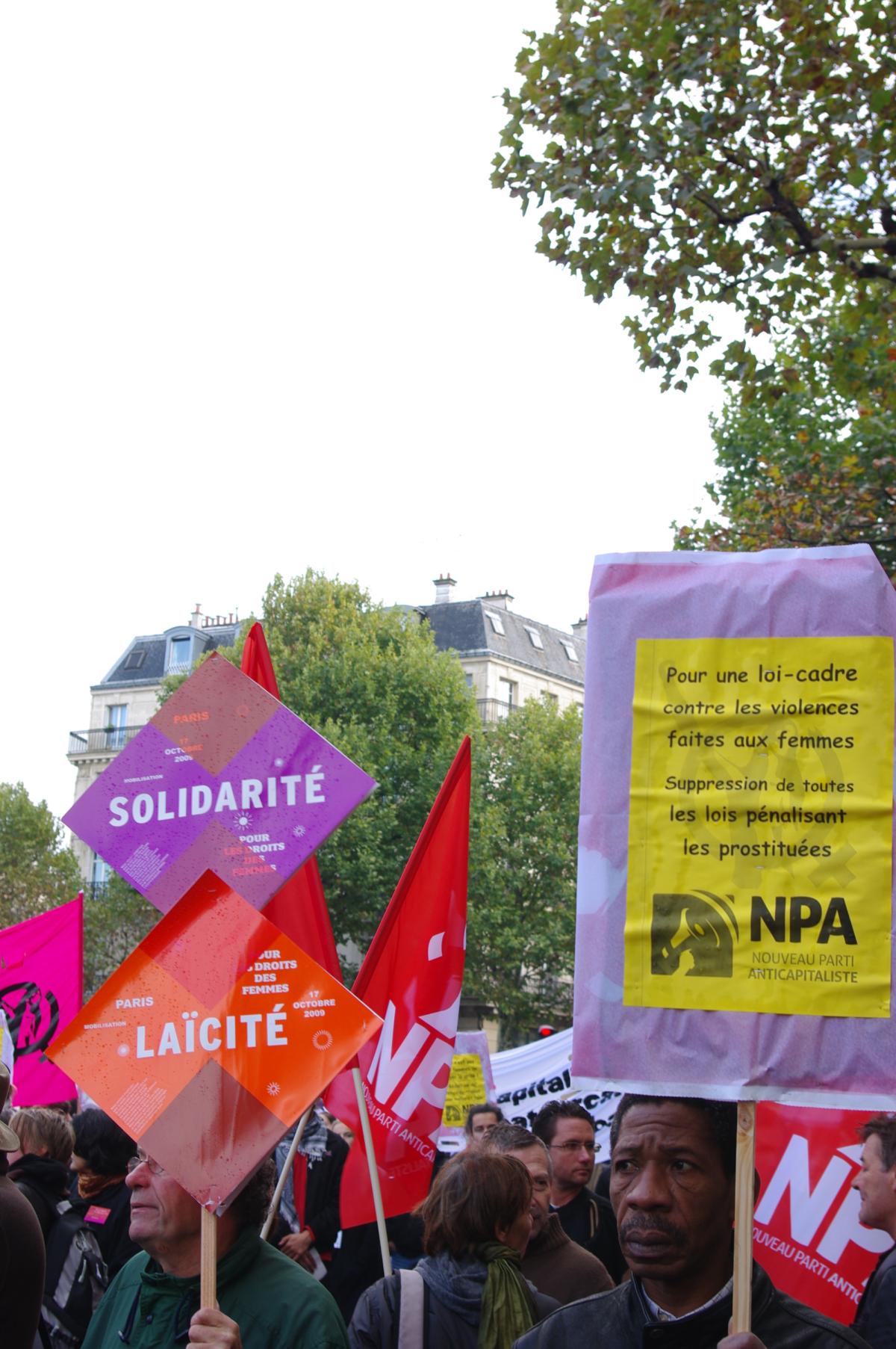 homme tenant une pancarte pour l'égalité salariale homme femme et foule