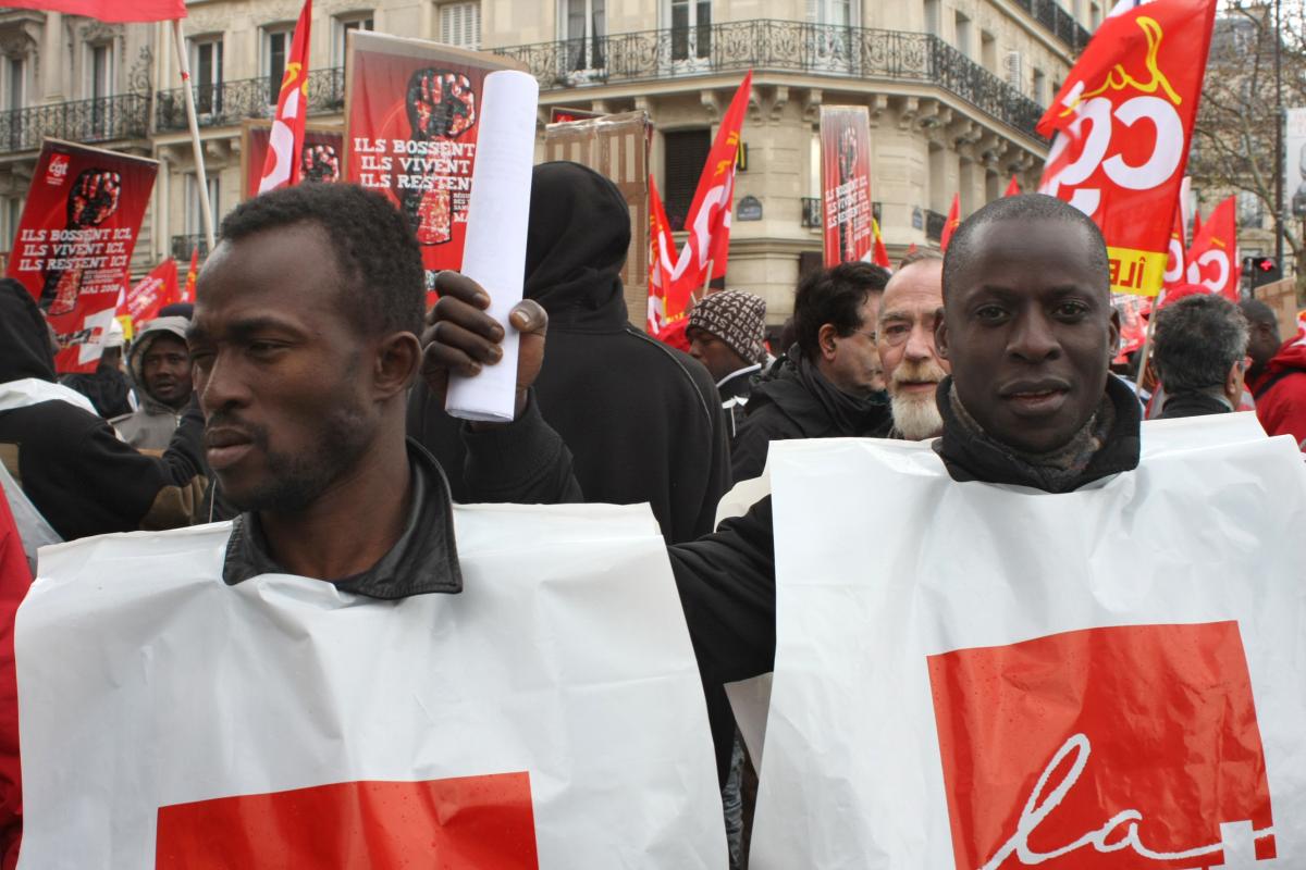 deux sans-papiers avec jaquette CGT