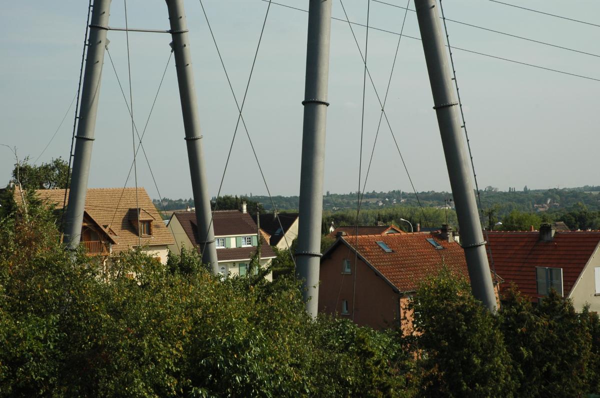 Poteau de haute tension électrique au dessus de maisons d'habitations ERDF ( Electricité réseau de distribution France).