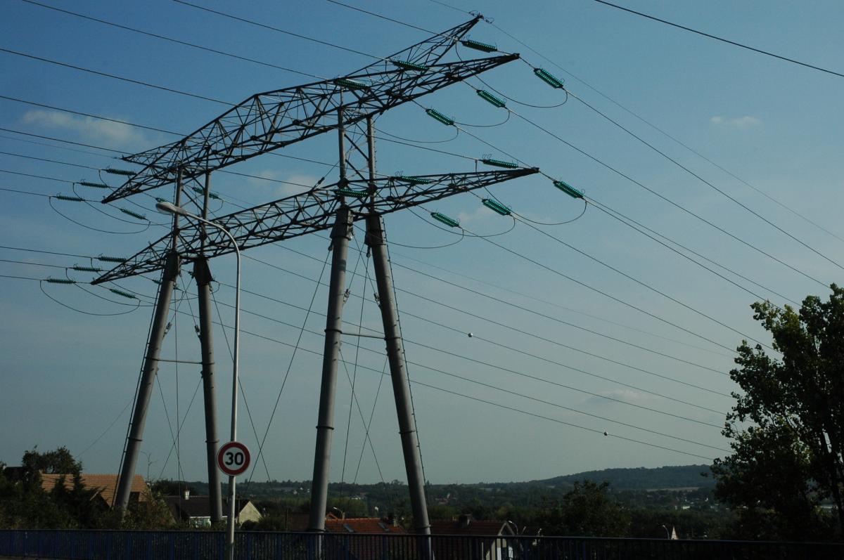 Poteau de haute tension électrique au dessus de maisons d'habitations ERDF (Electricité réseau de distribution France).