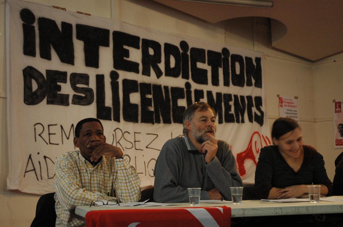 Tribune des candidats ile de France devant la banderole interdiction des licenciements.