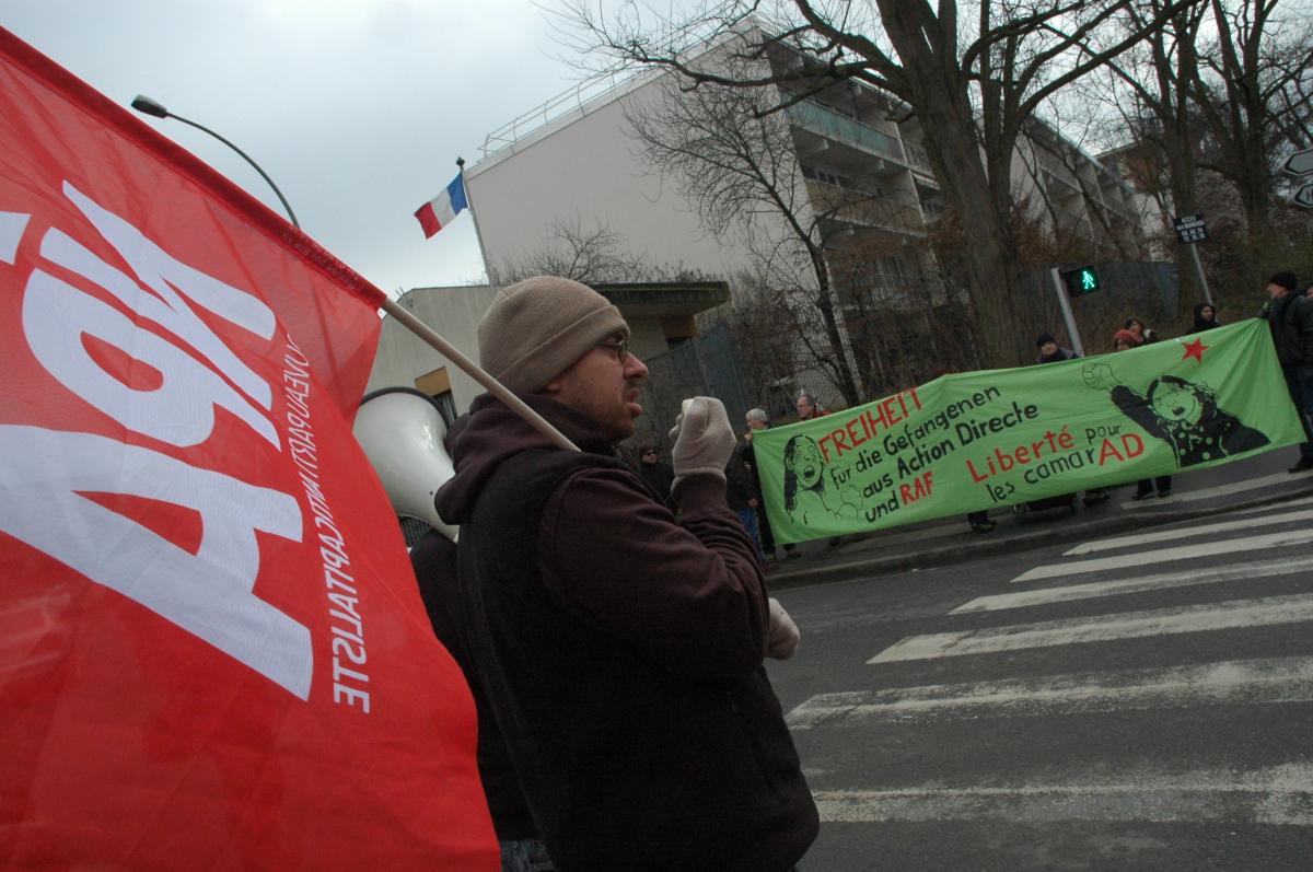 militant Npa avec drapeau et Sono, devant banderole Allemande de soutien aux prisonniers d'Action Directe.