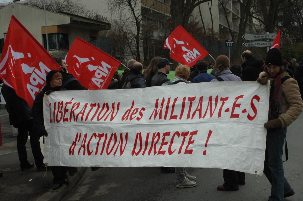 banderole Libération des Militant-es d'Action Directe et drapeaux Npa.