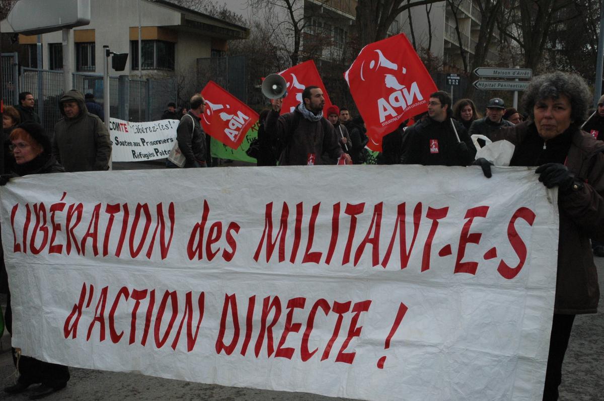 banderole Libération des Militant-es d'Action Directe et drapeaux Npa.