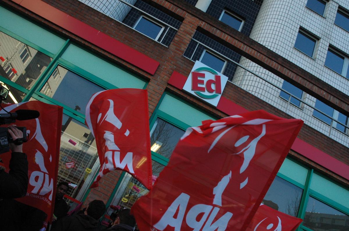Sigle ED d'Evry, magasin en grève depuis six semaines et drapeaux Npa.