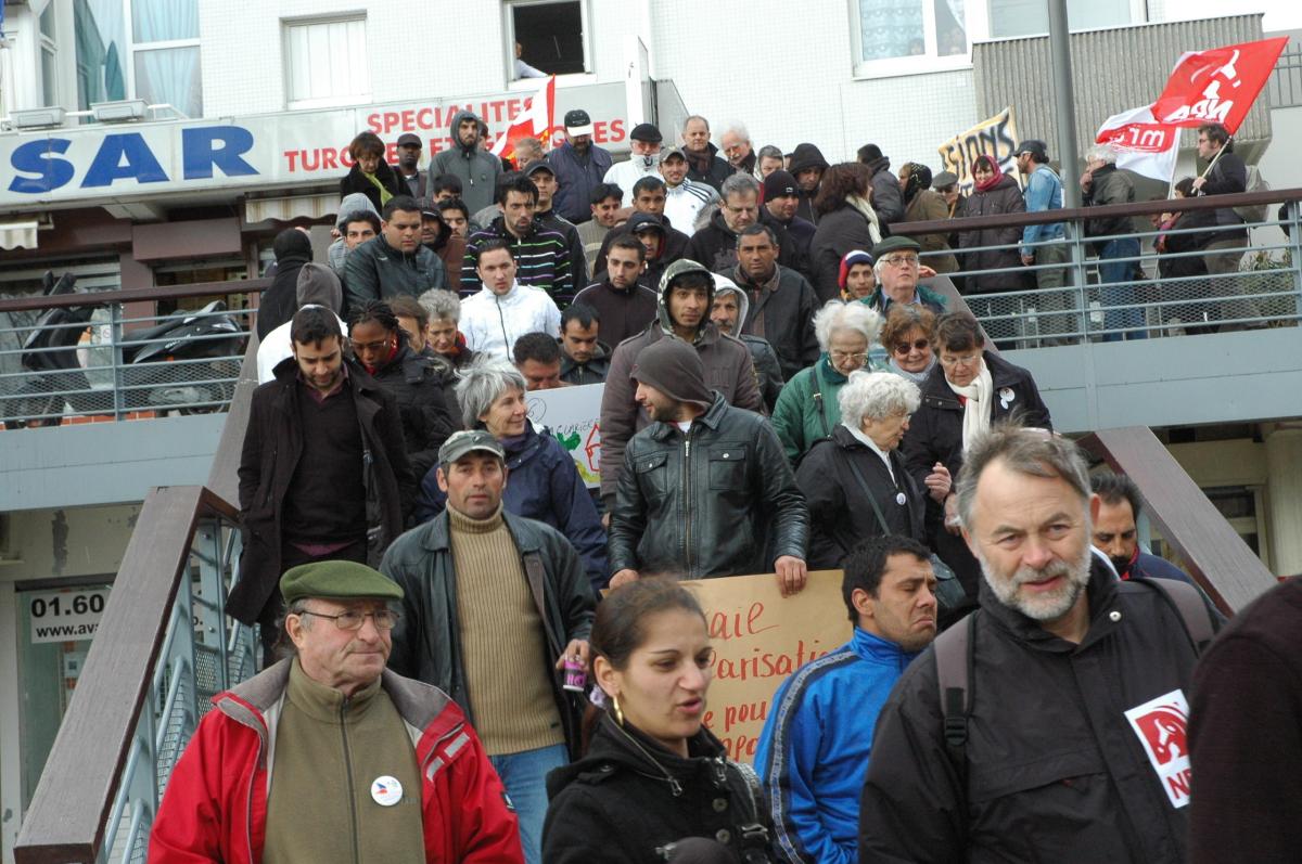 Roms Roumains devant drapeau Npa et Mrap à Evry.