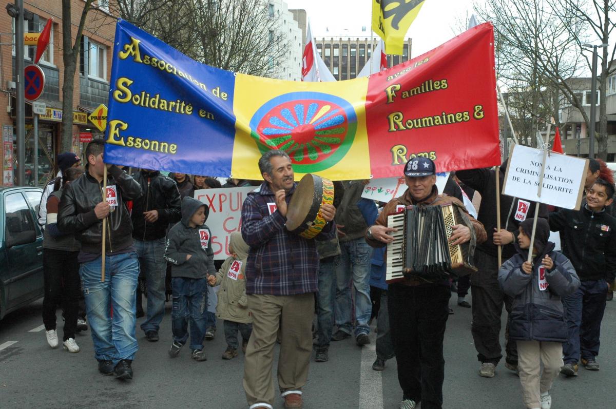 Rroms Roumains musiciens devant banderole de leur association à Evry.