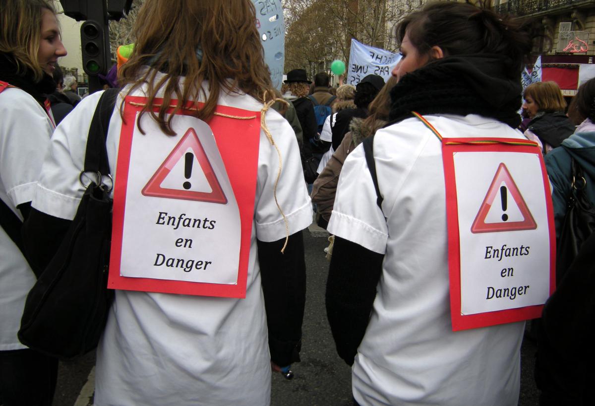 Manifestantes puéricultrices avec pancartes : enfants en danger