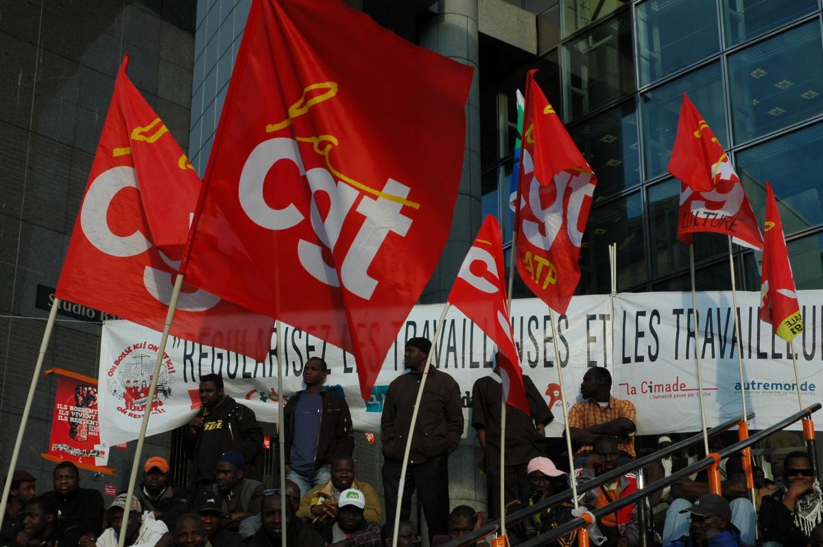 Banderole syndicale et Associative avec drapeaux Cgt et des Sans-Papiers sur les marches Opéra la Bastille.