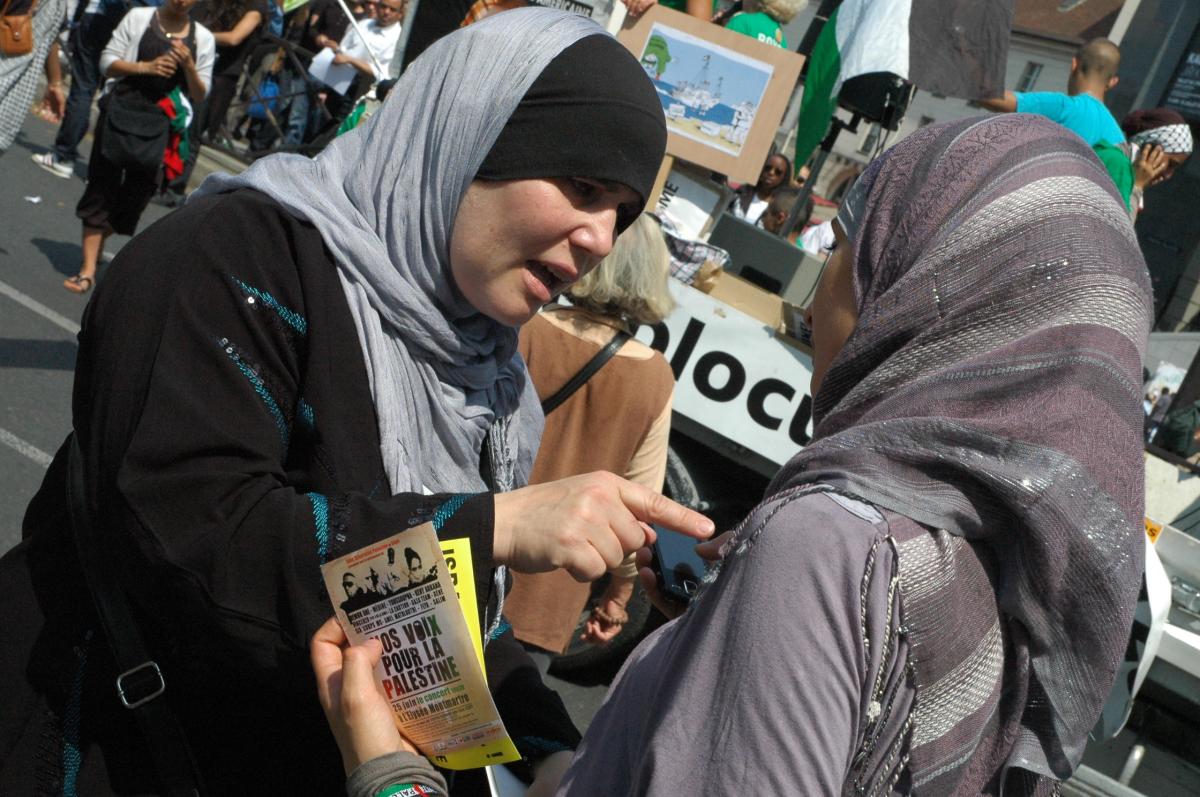 Femmes avec tract Nos voix pour la Palestine.