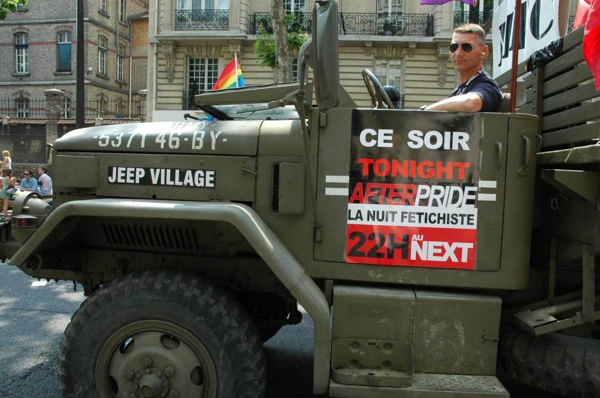camion militaire et publicité de boite de nuit à la Marche des Fiertés.