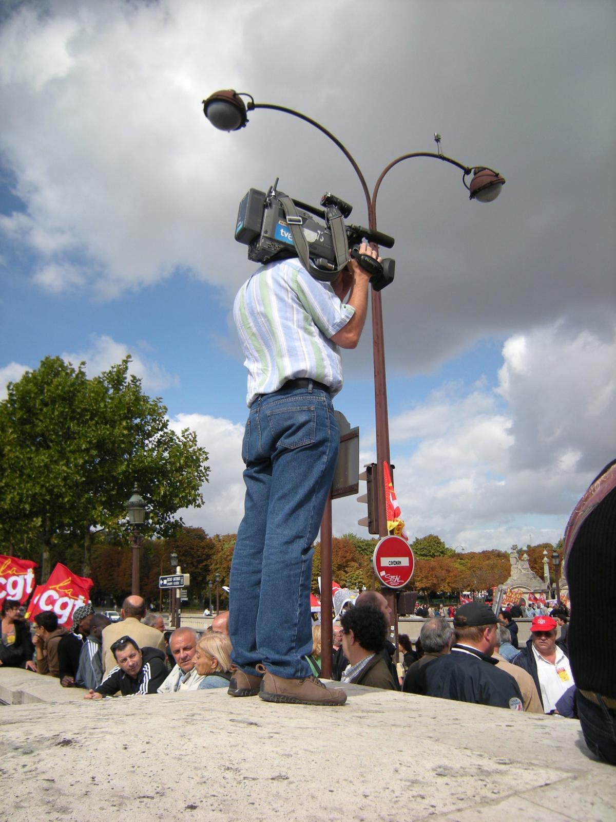 Journaliste caméraman filmant la foule