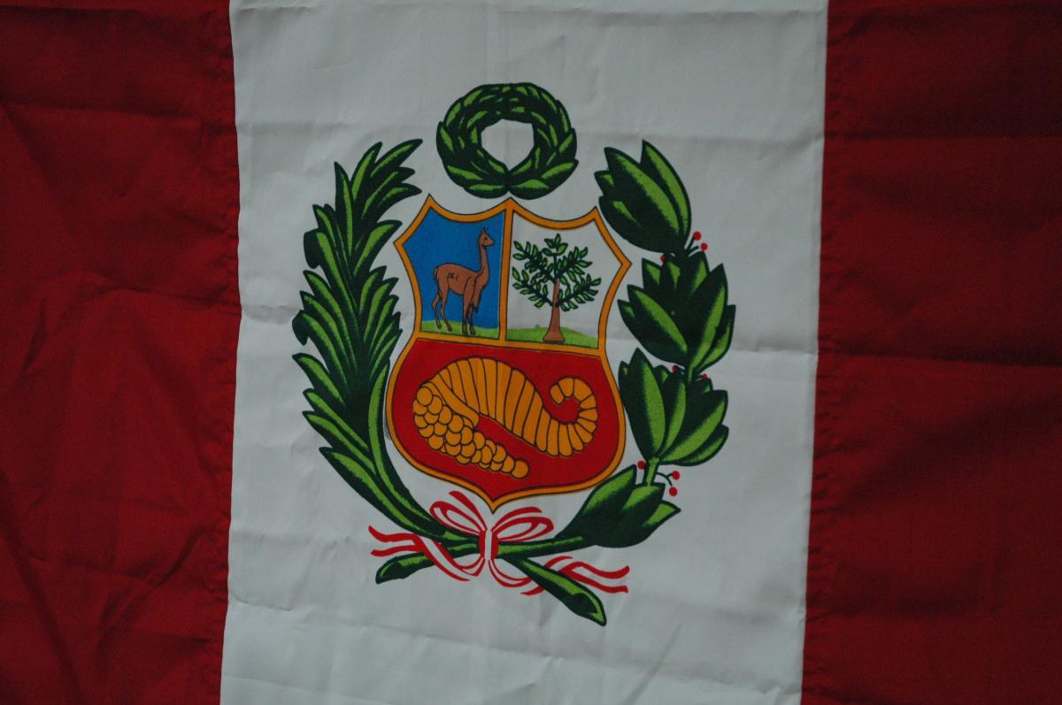 L'enseigne nationale (pabellón nacional) Elle porte, sur la bande centrale, les armoiries du Pérou (escudo de armas).