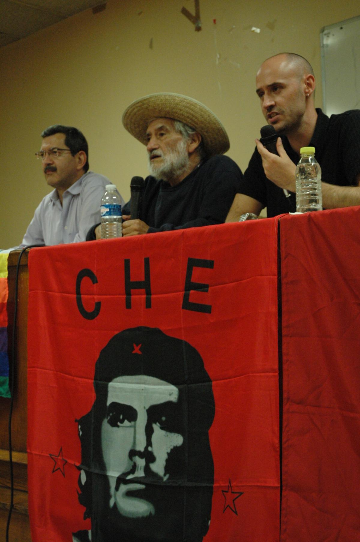 Hugo Blanco à la tribune avec drapeau de Che Guevara.