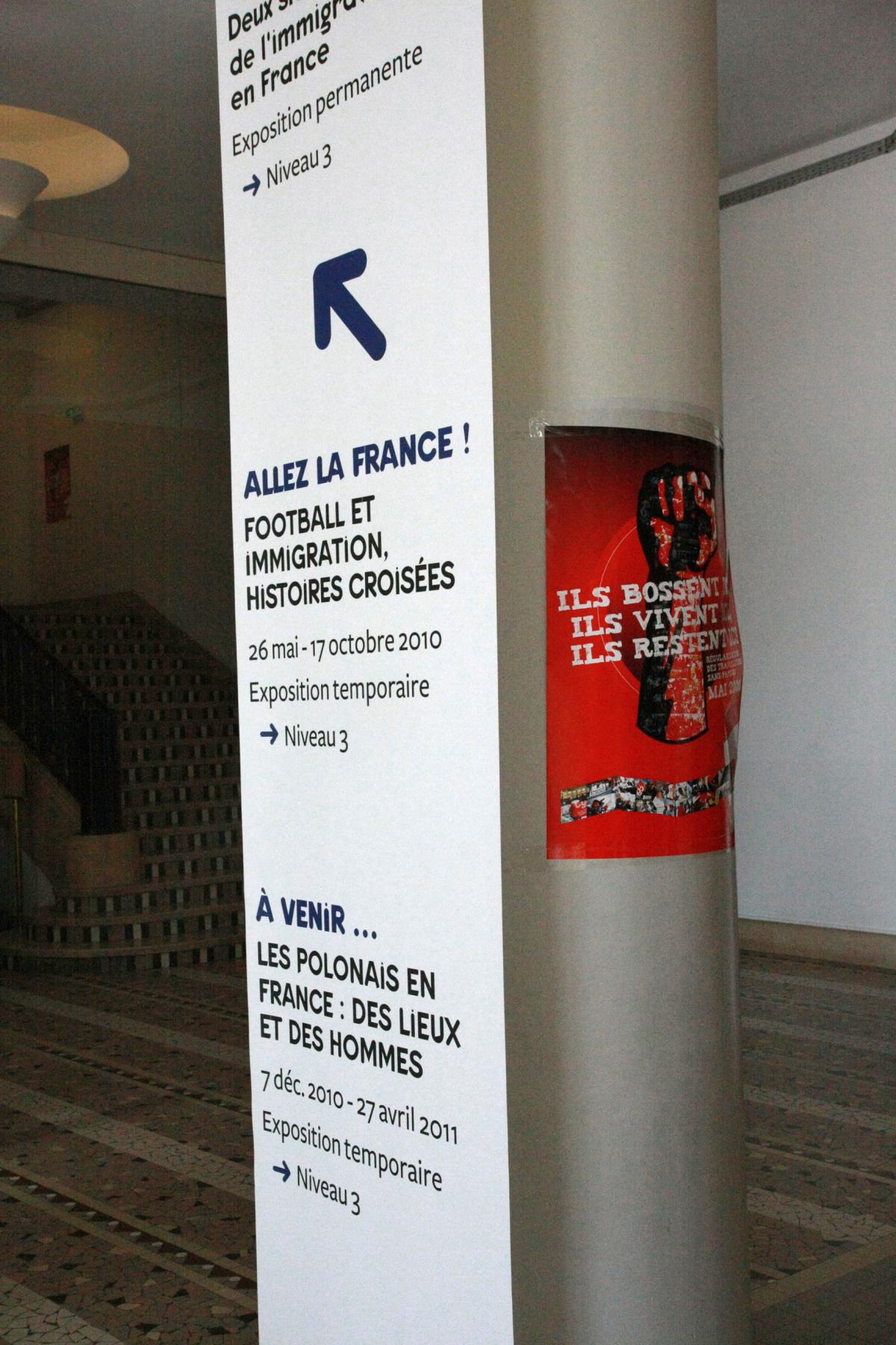 affiche des sans-papiers à côté du programme de la Citée