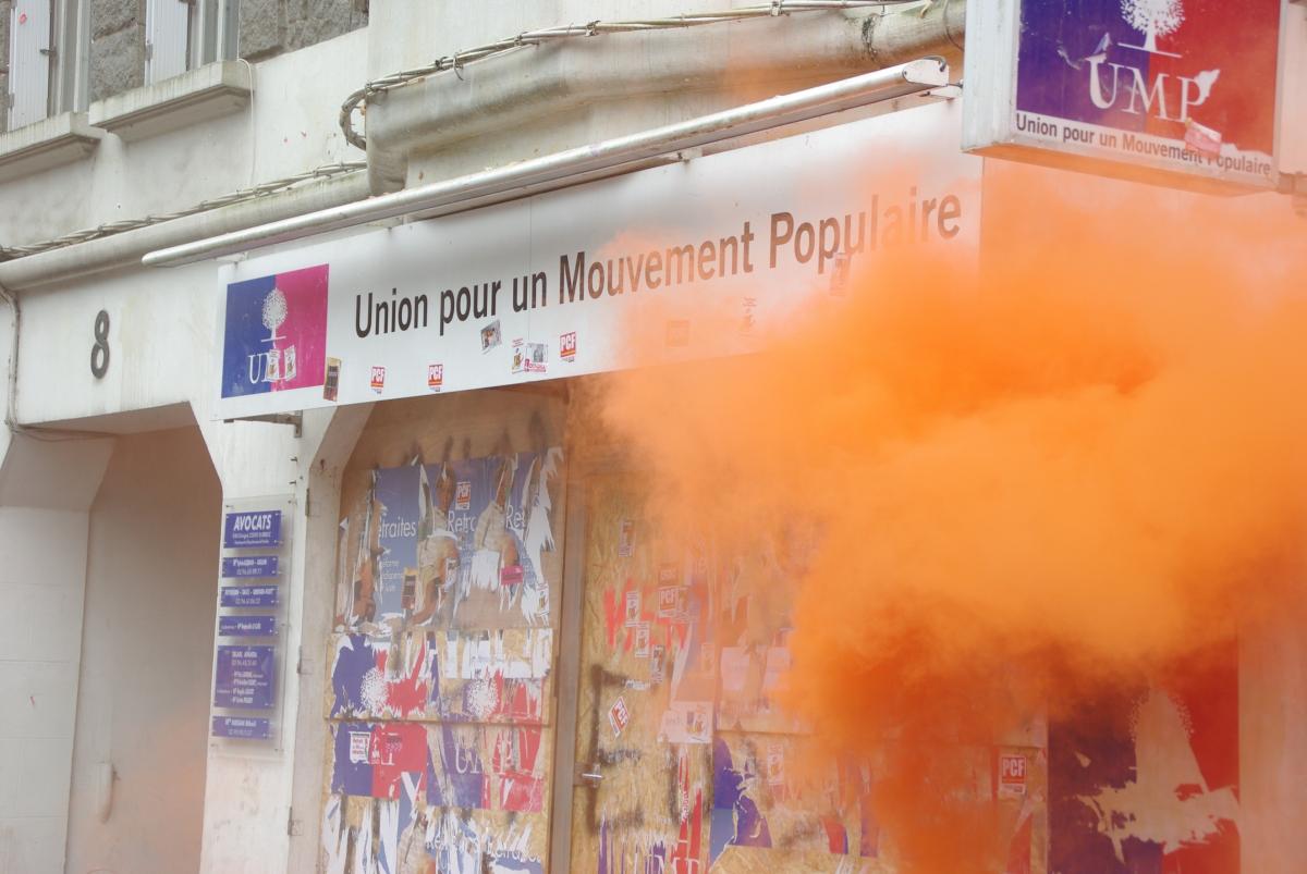 fin de la fumigène devant le local UMP de saint brieuc redécoré par les manifestants après que de sjeune spopulaires aient dérobé des banderoles syndicales