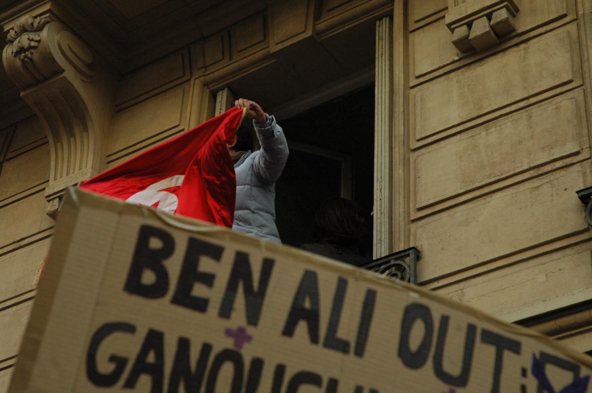 affiche Ben ali OUT à la fenêtre drapeau Tunisien brandit à la foule de manifestants