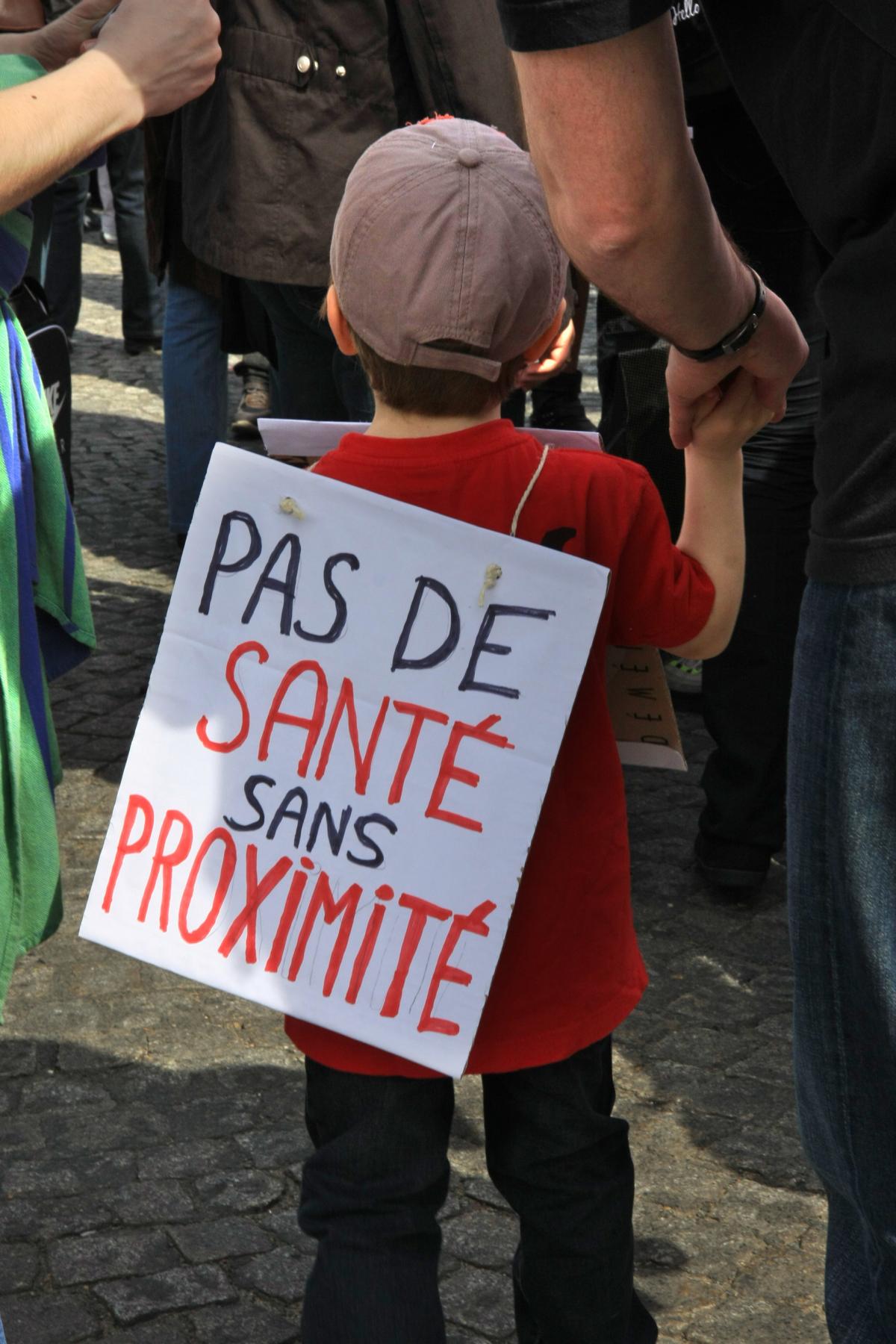 gamin avec pancarte pas de santé sans proximité