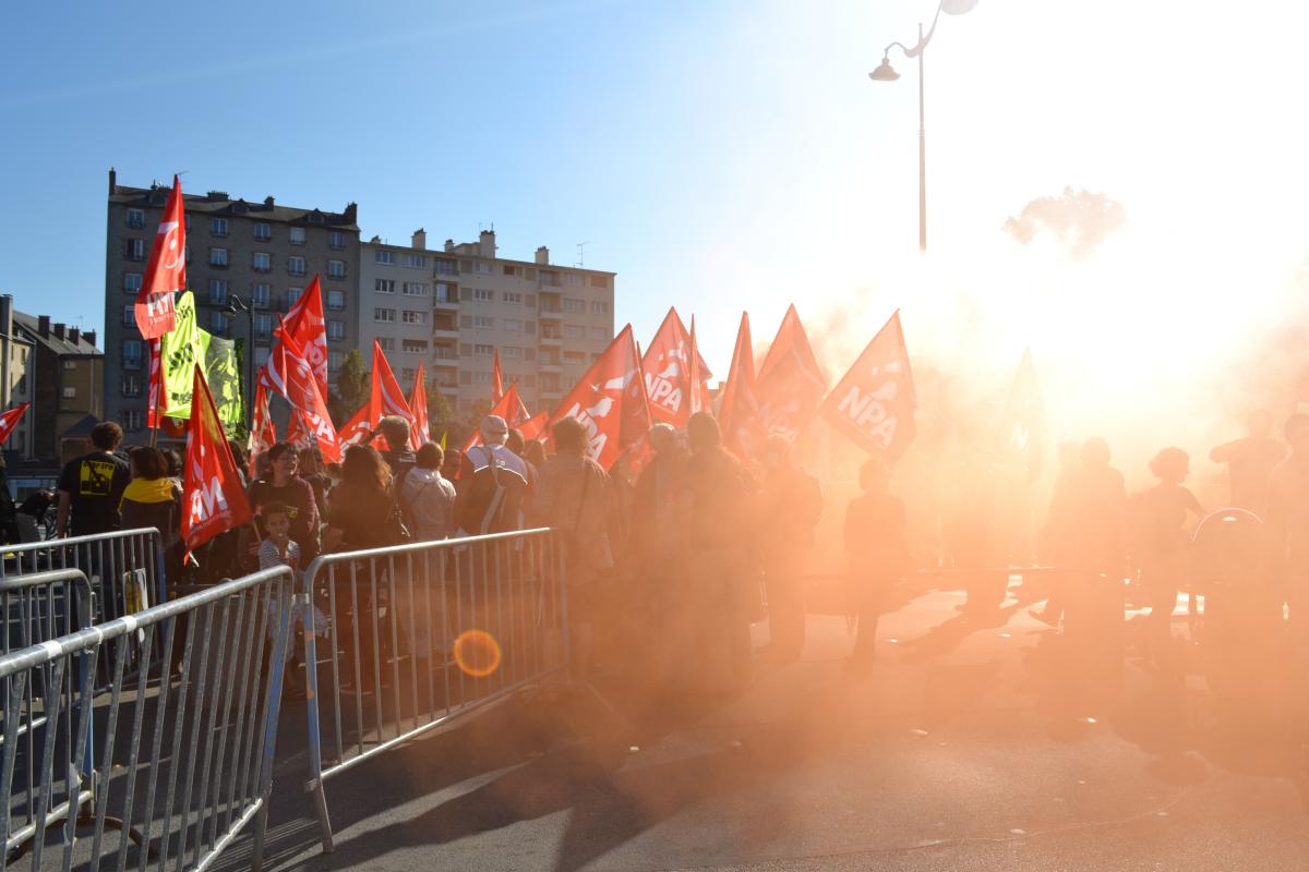 Groupe de personnes, cortège du NPA dans la fumée de