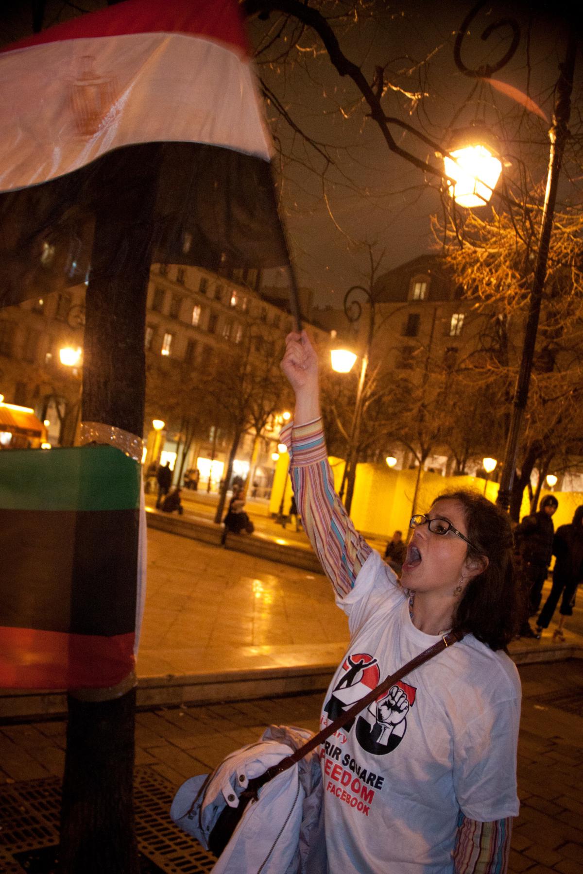Manifestante brandissant le drapeau égyptien et portant un t-shirt frappé de l'emblème du mouvement du 25 janvier.