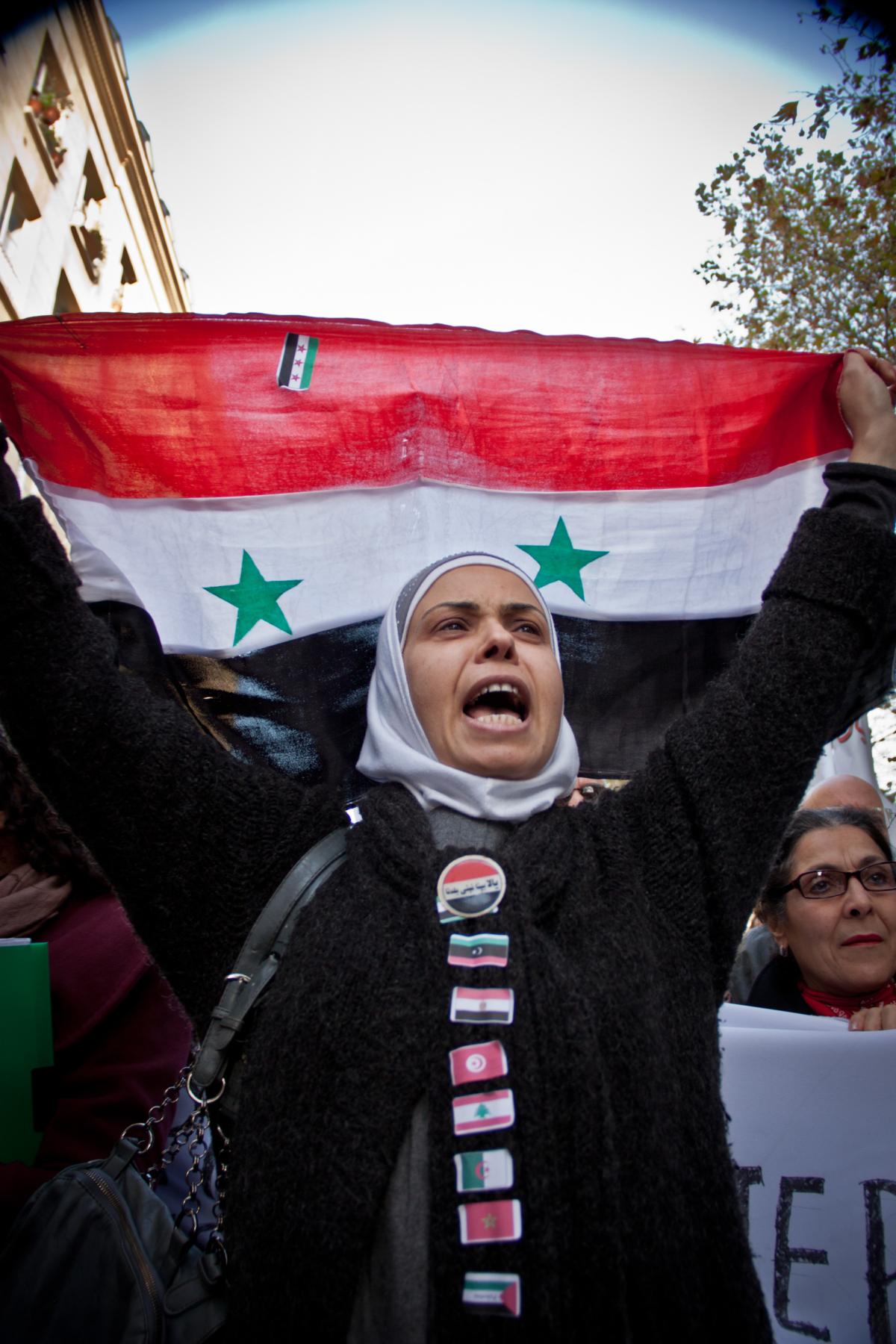Manifestante brandissant un drapeau syrien