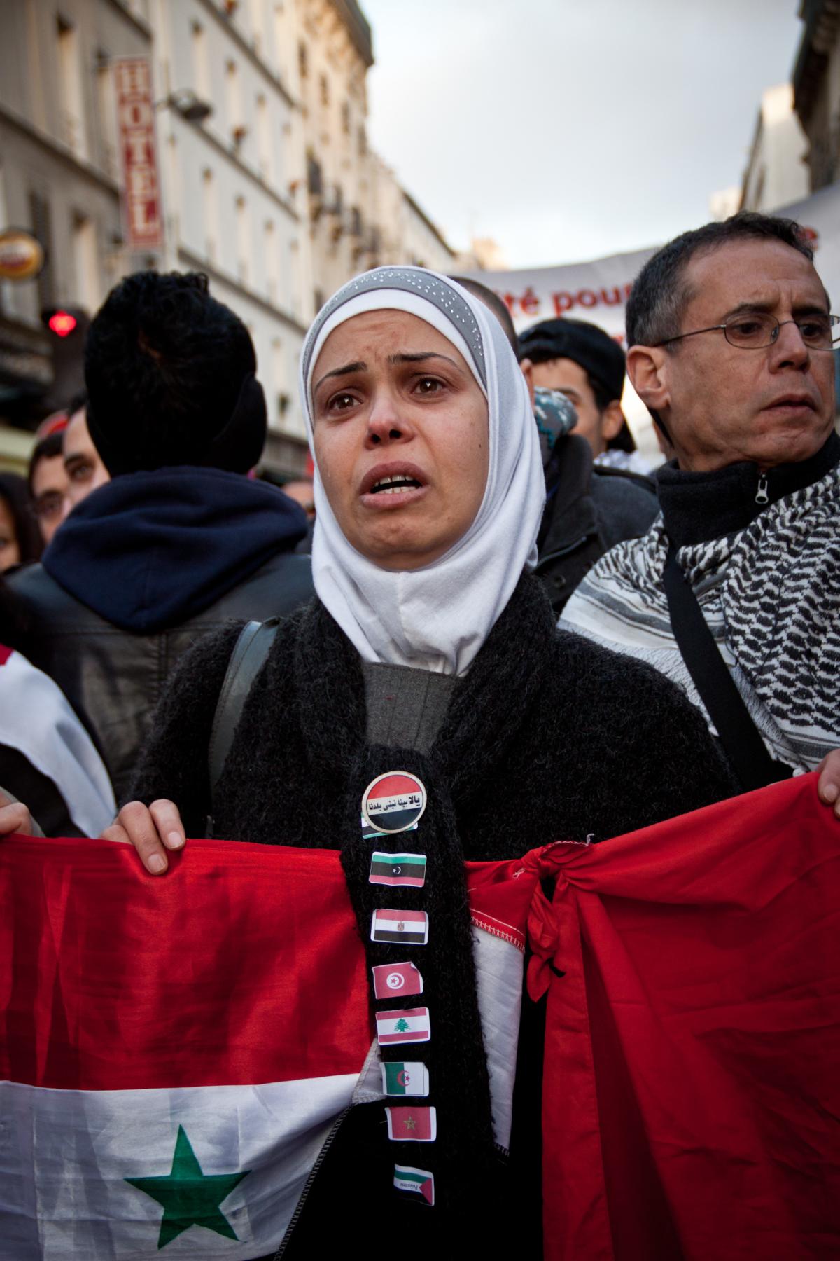 Manifestante en larmes, tenant le drapeau syrien.