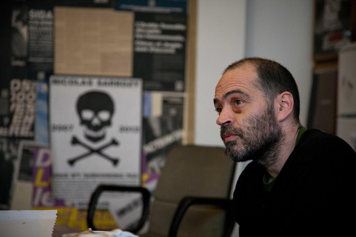 Denis Godard devant une affiche