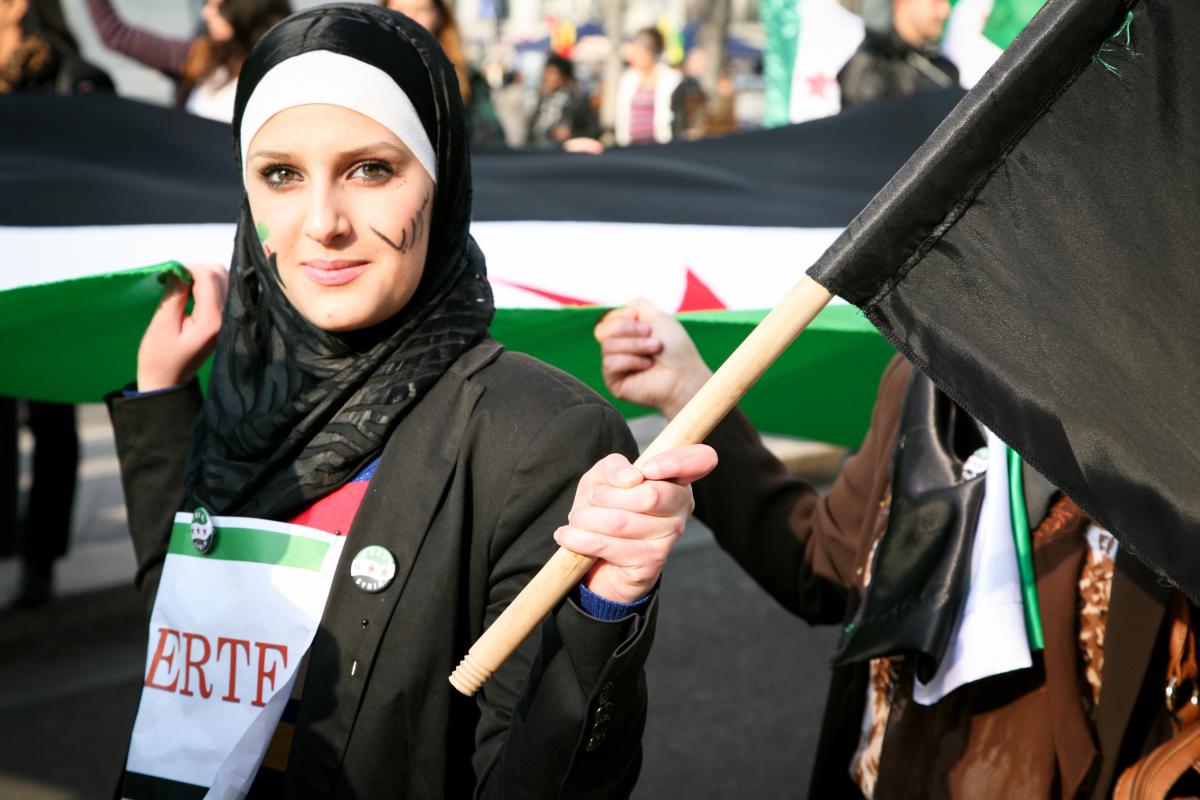 Jeune manifestante tenant le drapeau syrien.