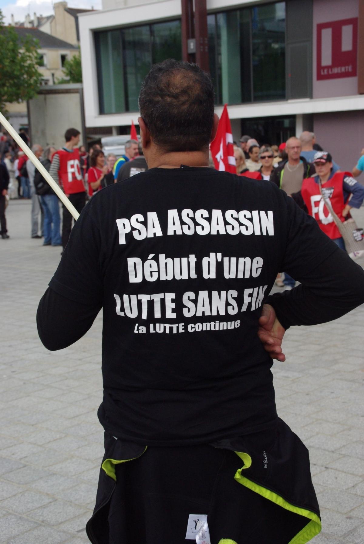 Ouvrier de l'usine d'Aulnay militant à Sud industrie tenant un drapeau et portant un Tshirt