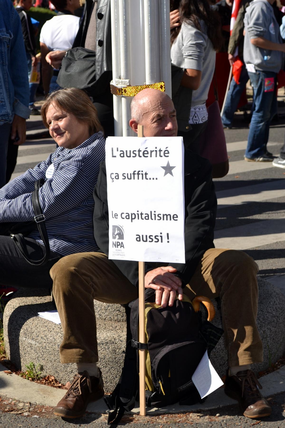 Militant NPA avec slogan ''L'austérité ça suffit... Le capitalisme aussi