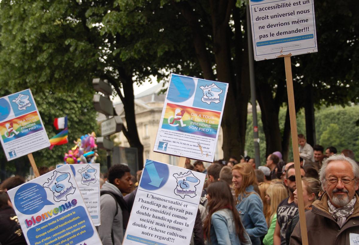 des militants handirebellion brandissent des pancartes: