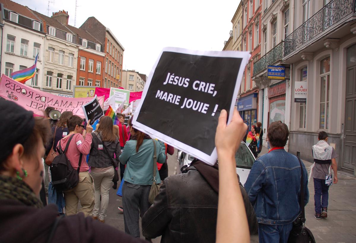 militante LGBT cortège Flamands roses tenant une pancarte:
