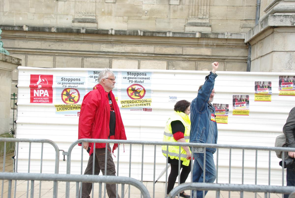 les syndicalistes rentrent dans le tribunal devant des affiches NPA