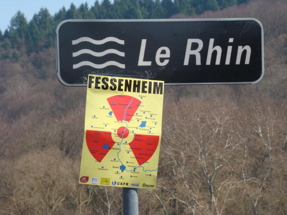 Le panneau de signalisation du Rhin associé à une affiche sur laquelle figure la zone d'impact d'une éventuelle catastrophe nucléaire à Fessenheim.
