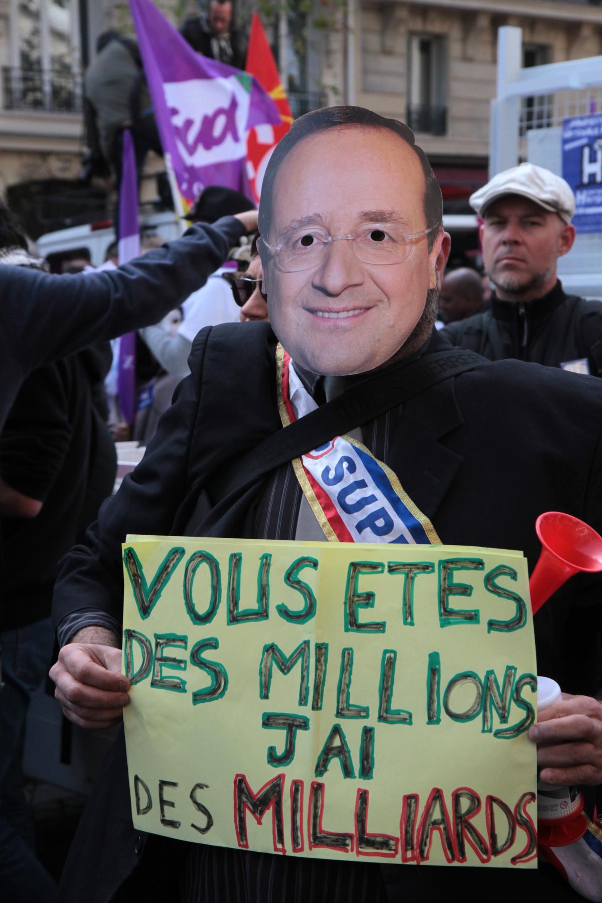 Portrait d'Hollande et pancarte vous êtes des millions j'ai des milliards.