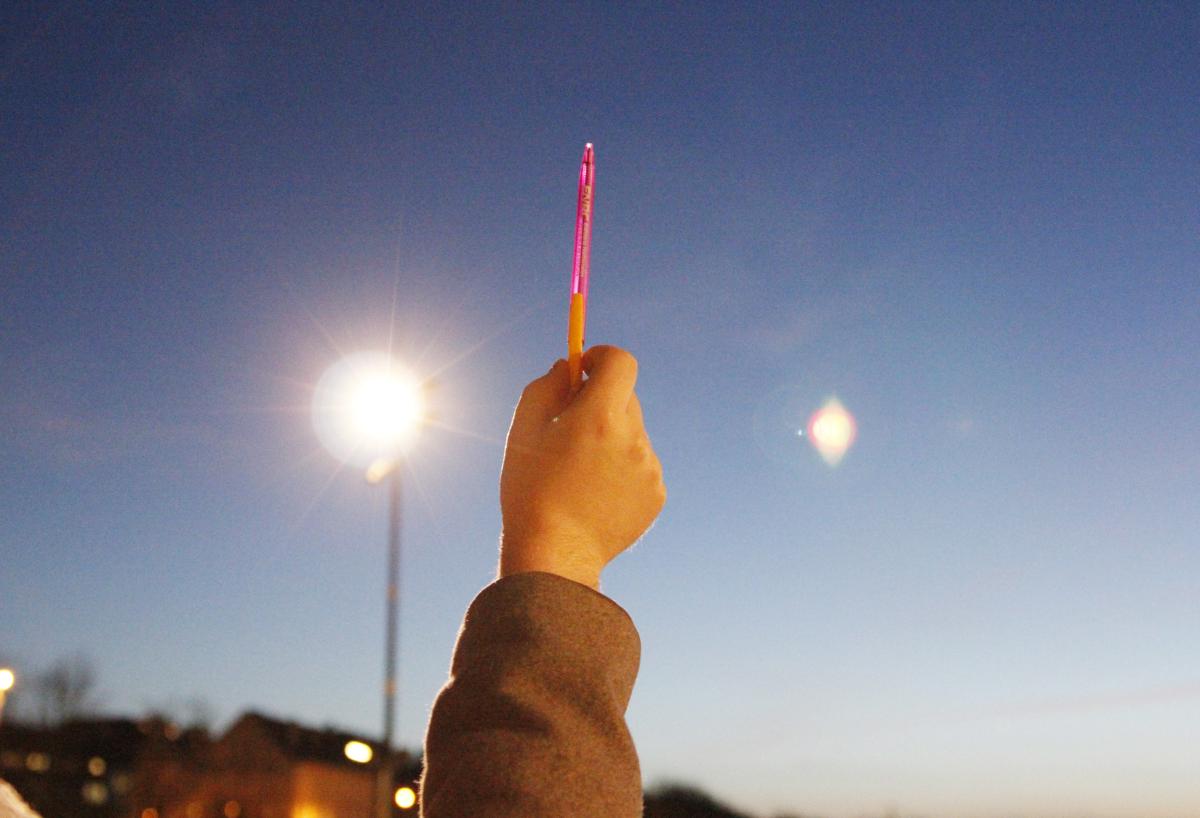 Main brandissant un stylo