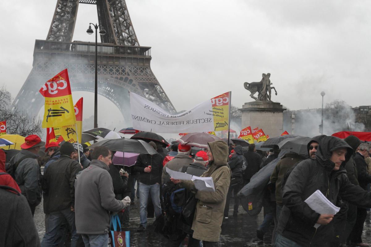 Diffusion du tract NPA cheminot avec Philippe Poutou, sur fond de Tour Eiffel