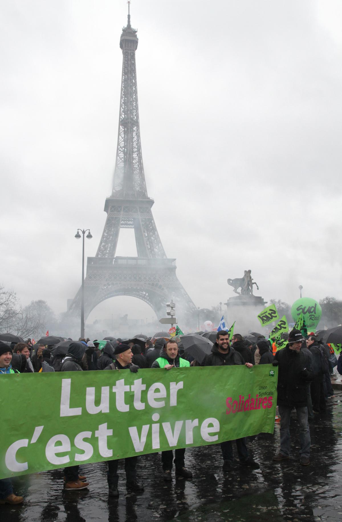 Banderole lutter c'est vivre sur fond de Tour Eiffel